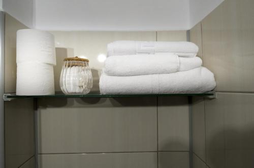 a pile of towels on a glass shelf in a bathroom at Casa Rusu -Victoria-Self check in-24h in Reşiţa