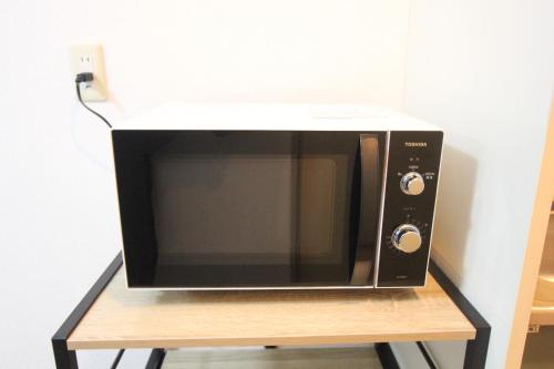 a microwave oven sitting on a wooden stand at LUANA in SHIBUYA in Tokyo