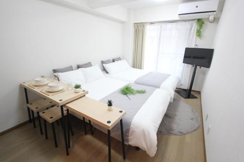 - une chambre avec un grand lit et une table dans l'établissement LUANA in SHIBUYA, à Tokyo