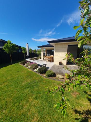 a house with a patio and a grass yard at 10 @ Wai Matangi in Turangi