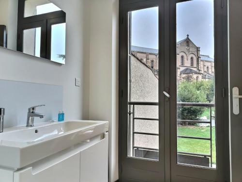 a bathroom with a sink and a view of a church at Le Coté Cour - Fibre - Clim - Centre-ville in Albi