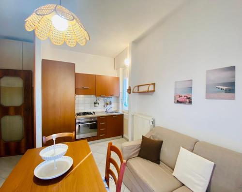 a living room and kitchen with a table and a couch at Hostdomus - La casina di Monica in Loano