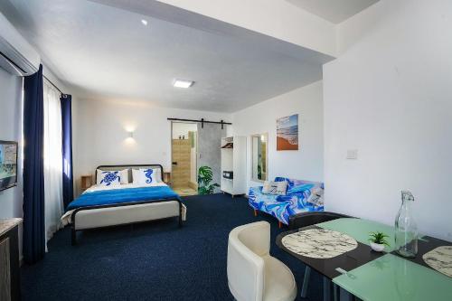 a bedroom with a bed and a desk and a table at C-view Apartments in Flic-en-Flac