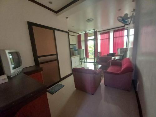 達沃市的住宿－1BR, 1BD condo Rentals, Toril，客厅配有两把椅子和电视