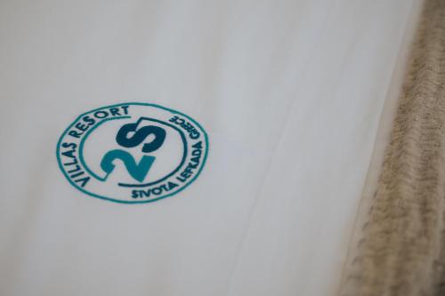 a sticker on the side of a toilet with a sign at 2S Villas Resort in Sivota