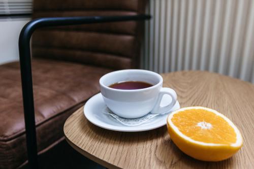 a cup of coffee and an orange on a table at Jaunmoku Palace Complex Hotel in Tume