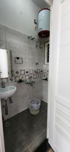 a bathroom with a shower with a sink and a toilet at Bhavasangama in Chikmagalūr