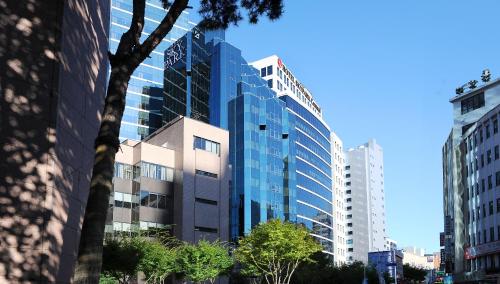 a tall building with glass windows in a city at Hotel Skypark Myeongdong 2 in Seoul