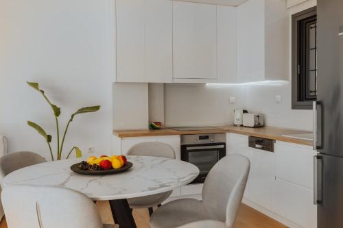 a kitchen with a table with a bowl of fruit on it at 2S Villas Resort in Sivota