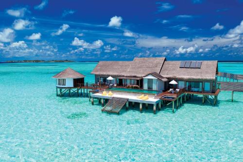 une maison dans l'eau sur une plage dans l'établissement OZEN LIFE MAADHOO - Luxury All Inclusive, à Atoll Malé Sud