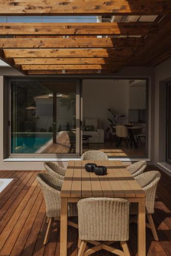 a dining room with a wooden table and chairs at 2S Villas Resort in Sivota