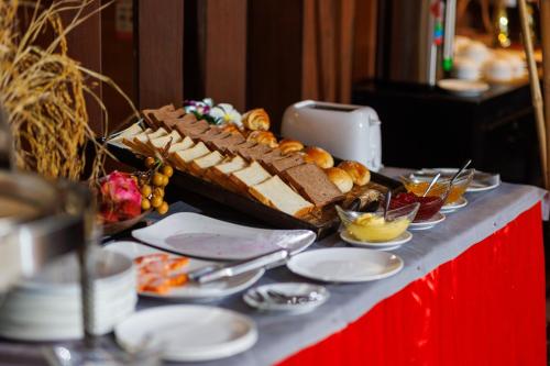 a table with a large cake and plates of food at RESIDENCE 1960 in Siem Reap