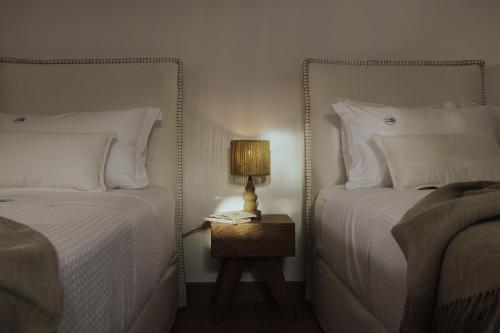 a bedroom with two beds and a lamp on a night stand at 2S Villas Resort in Sivota