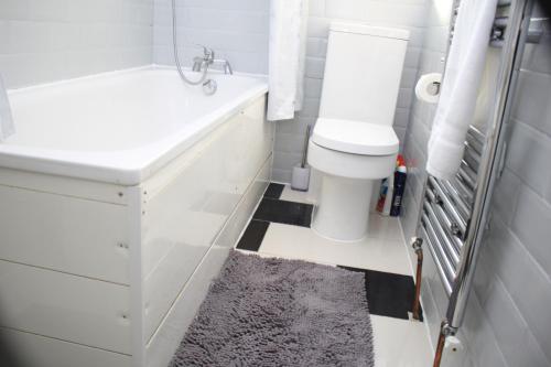 La salle de bains est pourvue de toilettes blanches et d'un lavabo. dans l'établissement Contractor's Bliss- 5-Bedroom House with Free Parking for 7 Guests, Super Fast Wifi- Fran Properties!, à Aylesbury