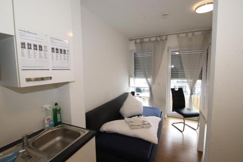 cocina con fregadero, sofá y silla en Apartments/Wohnungen direkt in Aschaffenburg, en Aschaffenburg