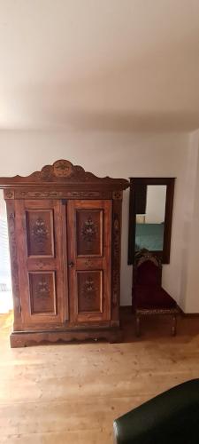 a wooden cabinet in a room with a mirror at Koasablick in Ebbs