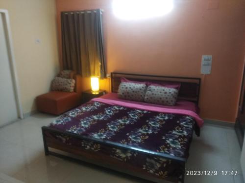 a bedroom with a bed and a lamp and a chair at Royale Seaward Supreme in Chennai