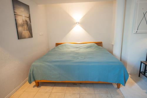 a small bedroom with a bed with a blue blanket at Kingsize Bett, Nahe Stadt und Alster, Ruhig in Hamburg