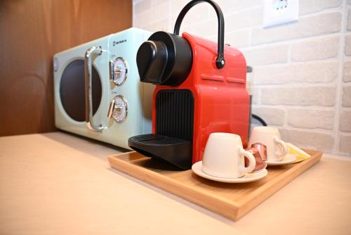 a red coffee maker sitting on a counter next to a toaster at Primula in Metsovo
