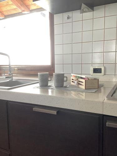 Casa Cavalier Peano في فيناديو: كوبين قهوة يجلسون على منضدة في مطبخ