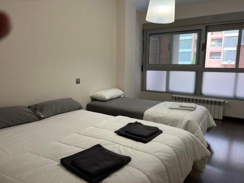 a bedroom with two beds and a large window at Amplio apartamento a 15 minutos de la puerta del Sol in Madrid