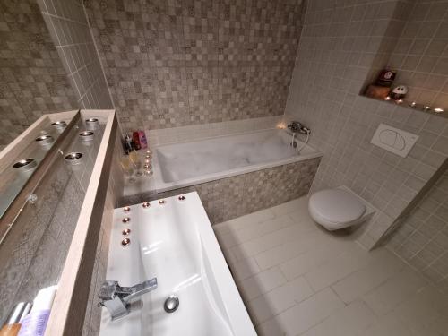 une salle de bain avec une baignoire blanche et des toilettes dans l'établissement Park Residence 5, 2 Bedroom Apartment, à Bucarest