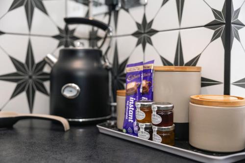 ein Tablett mit Marmeladen und Gewürzen auf der Theke in der Unterkunft The Nook Cottage, Parkgate, Wirral in Parkgate