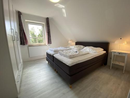 ein Schlafzimmer mit einem Bett in einem Zimmer mit einem Fenster in der Unterkunft Ostseesicht in Schönberger Strand
