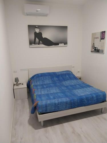 a bedroom with a bed with a blue comforter at Relais_Seriate in Seriate