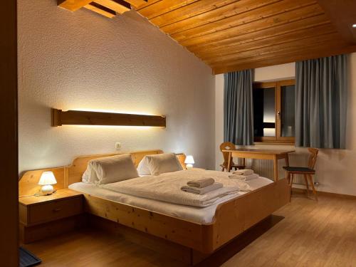 1 dormitorio con 1 cama grande y 1 mesa en Gasthof Paluda - Pizzeria, en Dalaas