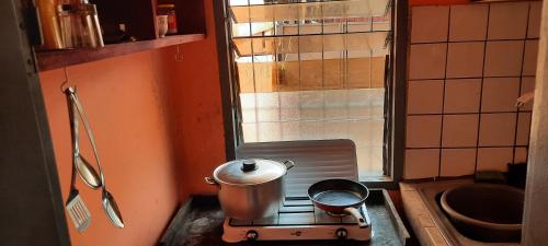una pequeña cocina con una olla en una estufa en Dalle Sutio meublé ETOUG-EBE, en Yaoundé