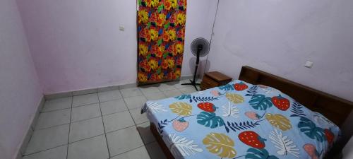 1 dormitorio con 1 cama con un patrón de fruta en Dalle Sutio meublé ETOUG-EBE, en Yaoundé