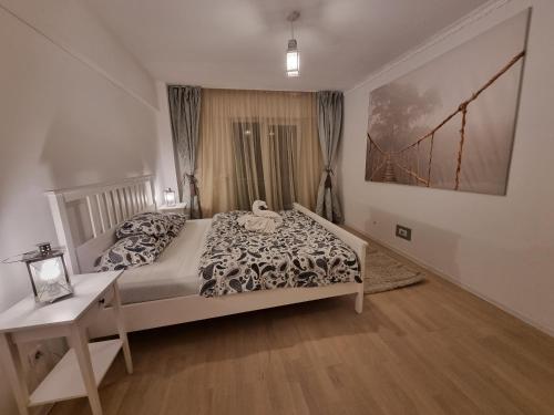 - une chambre avec un lit, une table et une photo dans l'établissement Park Residence 5, 2 Bedroom Apartment, à Bucarest