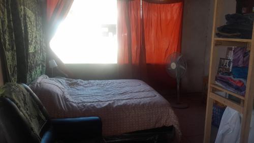 a small bedroom with a bed and a window at La Apacheta in San Roque