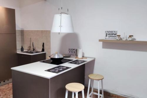 a kitchen with a stove and two stools at Nel cuore di Torino in Turin