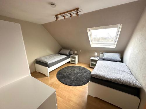 een kleine kamer met 2 bedden en een tapijt bij Ferienwohnung in Ettinghausen 