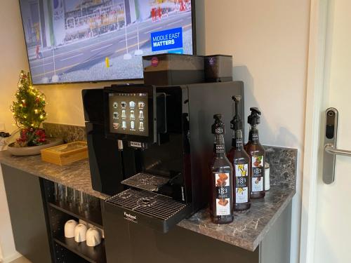 a coffee maker on a counter with bottles of alcohol at CPH Like Home in Copenhagen
