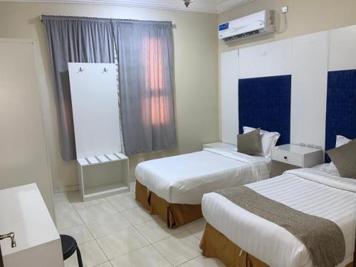 a hotel room with two beds and a window at الفخامة الجنوبية للشقق المخدومة in Jazan