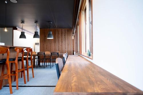 a dining room with a long wooden table and chairs at ロッヂモントゼー in Yuzawa