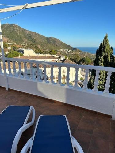 Un balcón con sillas y vistas al océano. en Preciosa casa adosada en Mijas, en Mijas