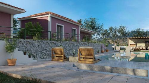 una casa con 2 sillas y una piscina en Lorraine's Apartments close to Lourdas Beach, en Cefalonia