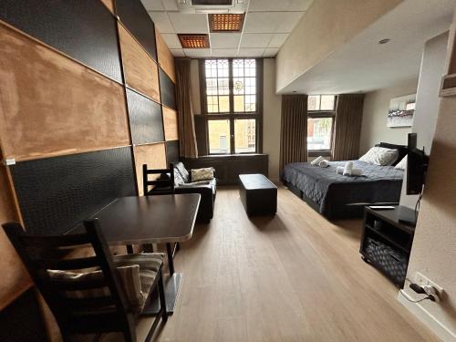 a living room with a bed and a room with a table at Amazing independent Studio S3, City Centre Dordrecht in Dordrecht