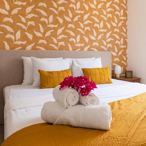 a bedroom with a bed with towels and flowers on it at Palm Suite - Newly constructed poolside apartment just minutes from the beach in Jan Thiel