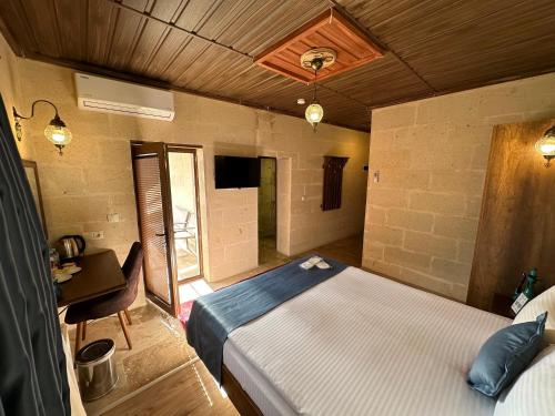 a bedroom with a bed and a desk in a room at Virtus Cappadocia Hotel Göreme in Goreme