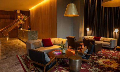 Next Hotel Melbourne, Curio Collection by Hilton في ملبورن: غرفة معيشة مع أريكة وطاولة