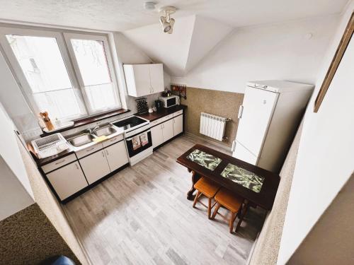 a small kitchen with a table and a refrigerator at Villa Beata in Nowy Sącz