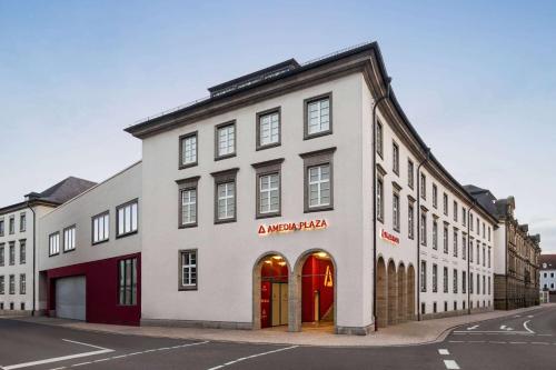 um edifício branco com portas vermelhas numa rua em Amedia Plaza Speyer, Trademark Collection by Wyndham em Speyer