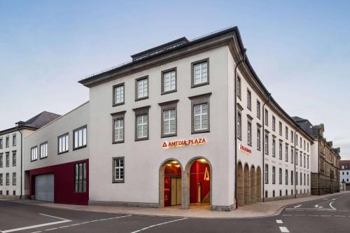 Amedia Plaza Speyer, Trademark Collection by Wyndham في شباير: مبنى أبيض بأبواب حمراء على شارع