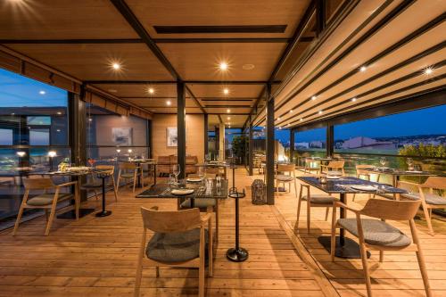 un restaurante con mesas y sillas en una terraza en Chania Flair Boutique Hotel, Tapestry Collection by Hilton, en La Canea