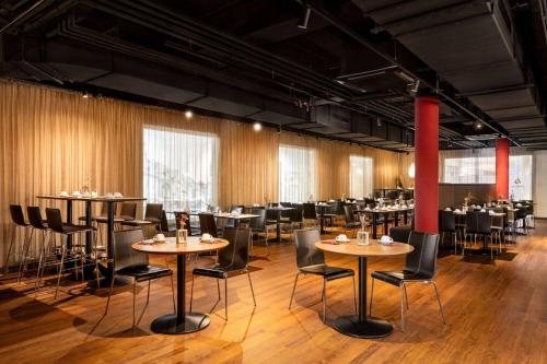 a restaurant with tables and chairs in a room at Amedia Plaza Speyer, Trademark Collection by Wyndham in Speyer